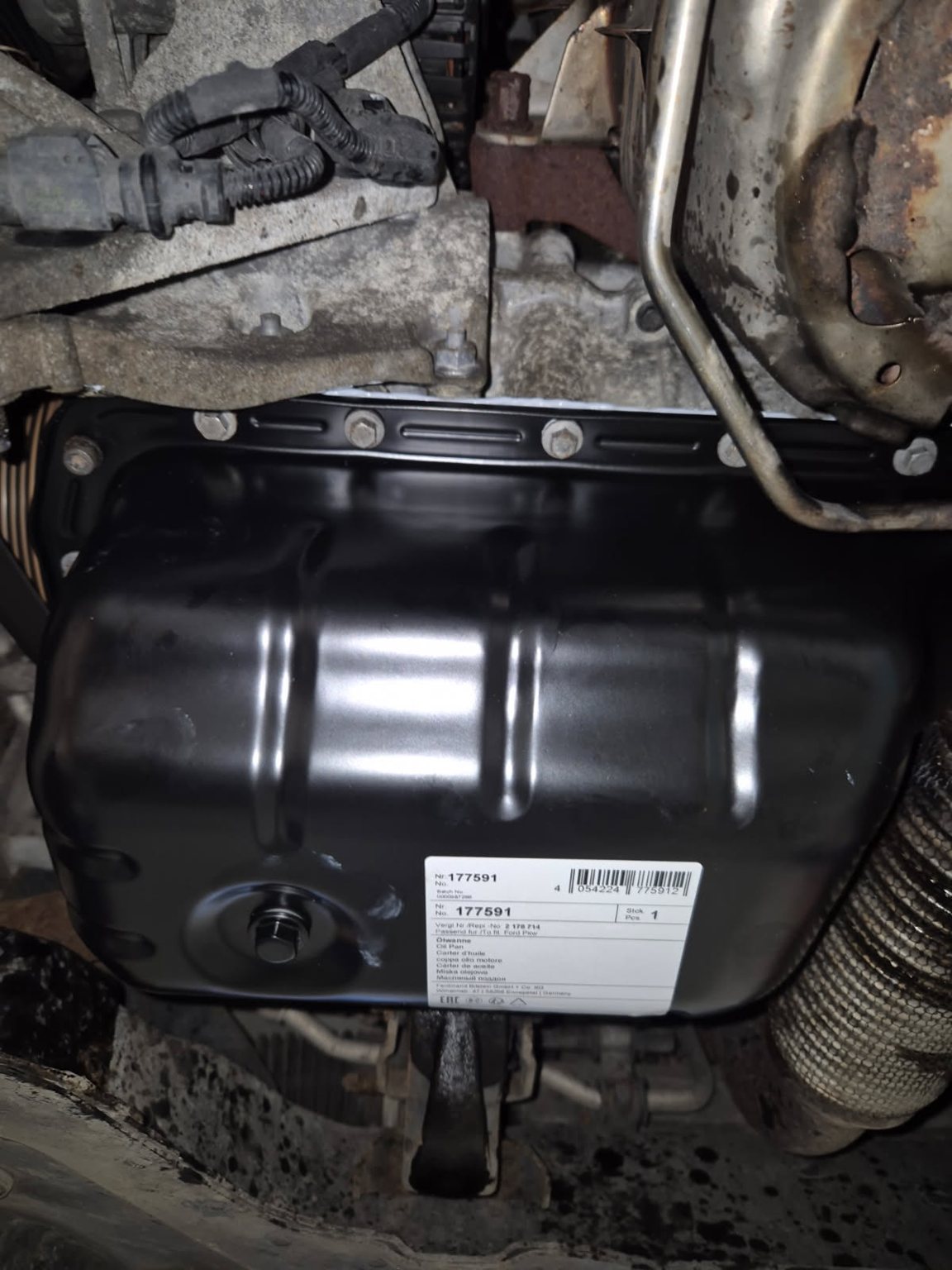 The underside of a car with a new part fitted, its label still on