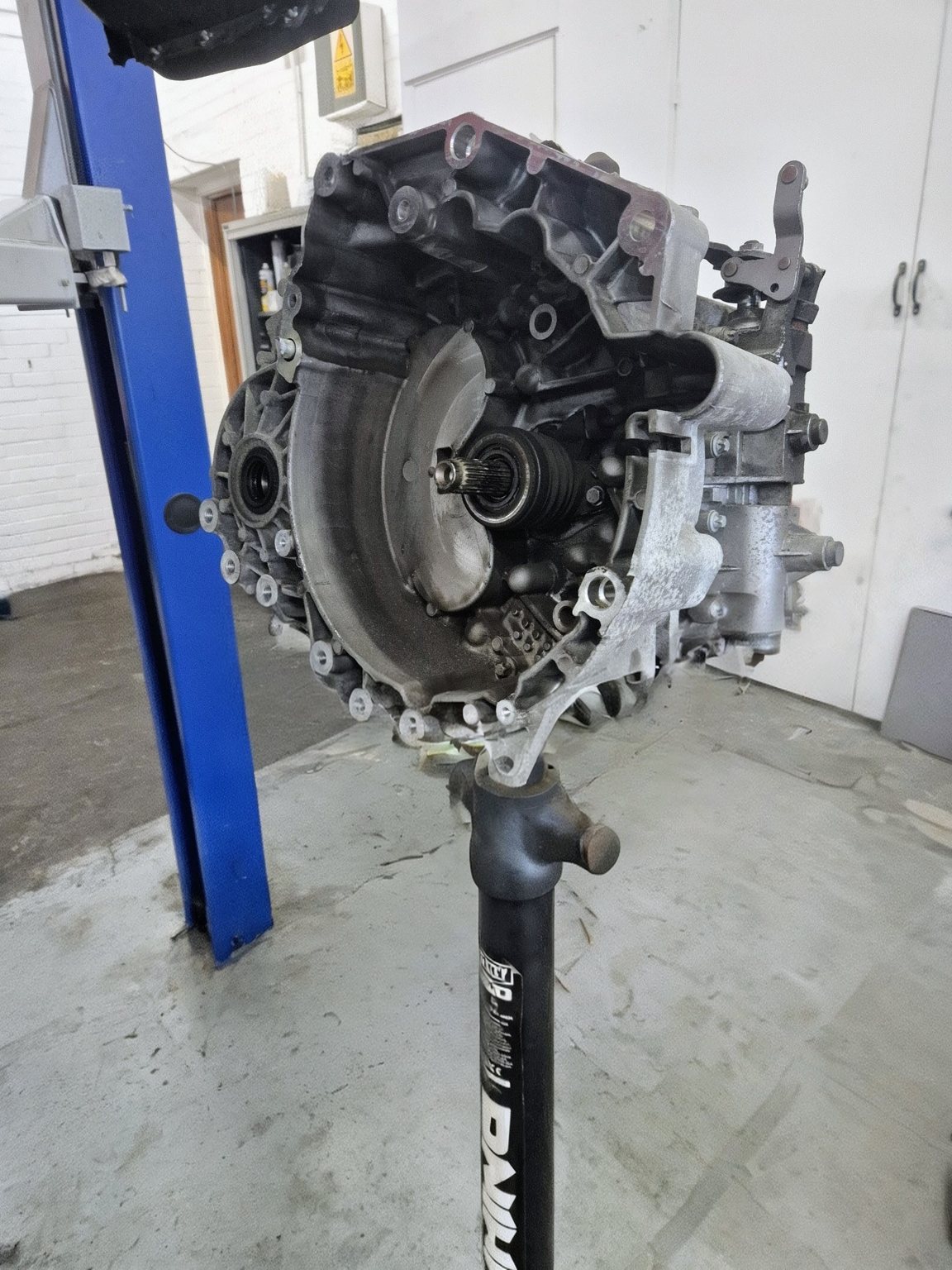 A gearbox on a transmission jack beside the two-post lift in the Marsh Auto Services workshop