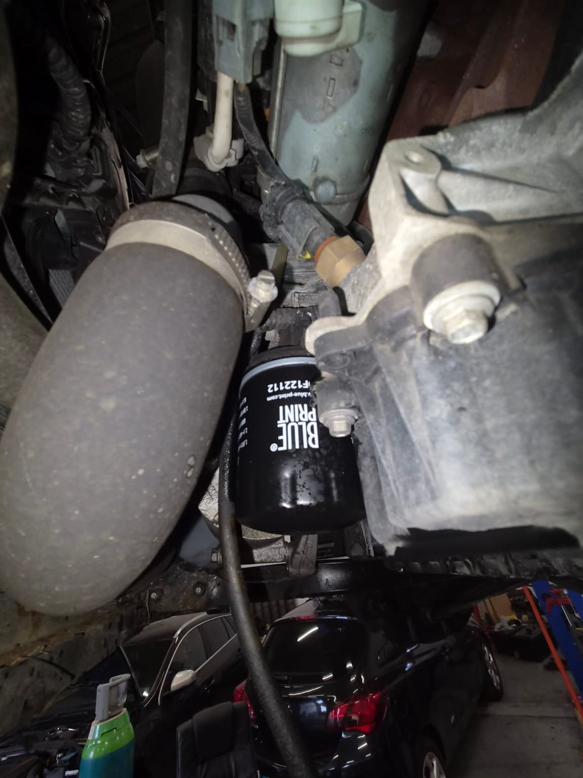 A new oil filter fitted under a car